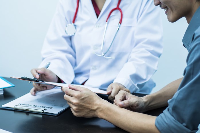 Doctor and patient working together to fill out medical forms.