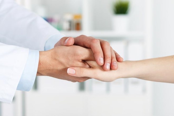 Behavioral health doctor and patient holding hands.