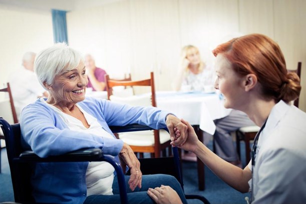 Millennial caregiver taking care of elderly patient.