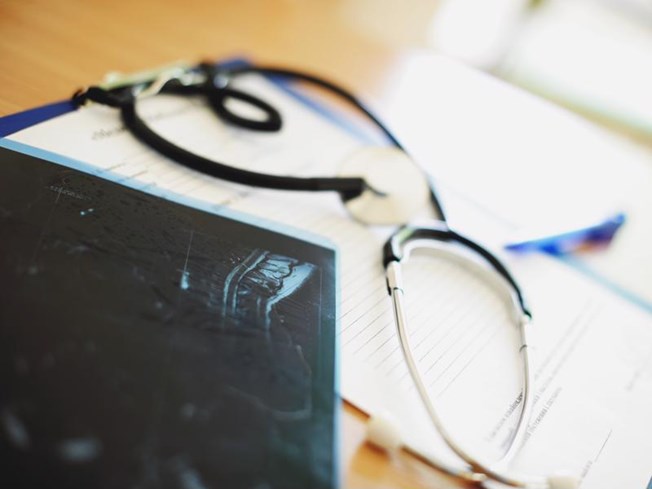 A tablet next to notes on evidence-based medicine taken by a physician.