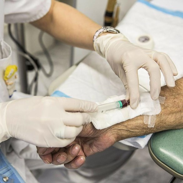 A doctor drawing blood from a patient to research.